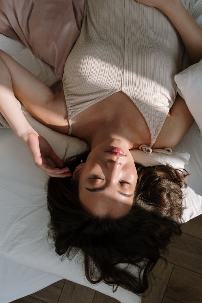 A serene portrait of a woman peacefully sleeping, bathed in gentle sunlight.